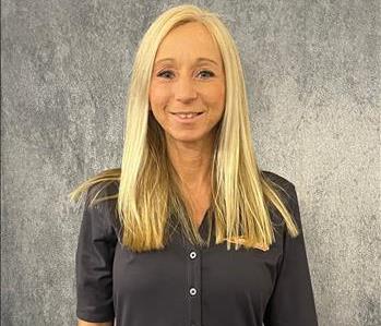 Female employee standing in front of grey backdrop